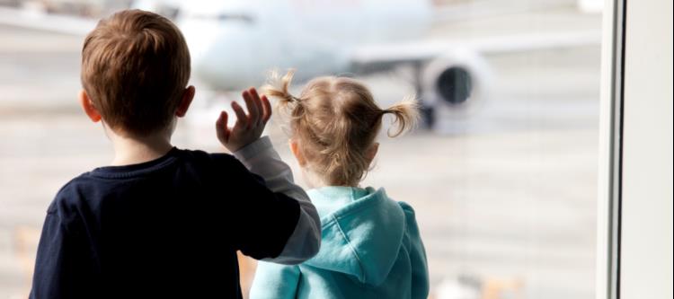 Kids looking at aircraft through the terminal window