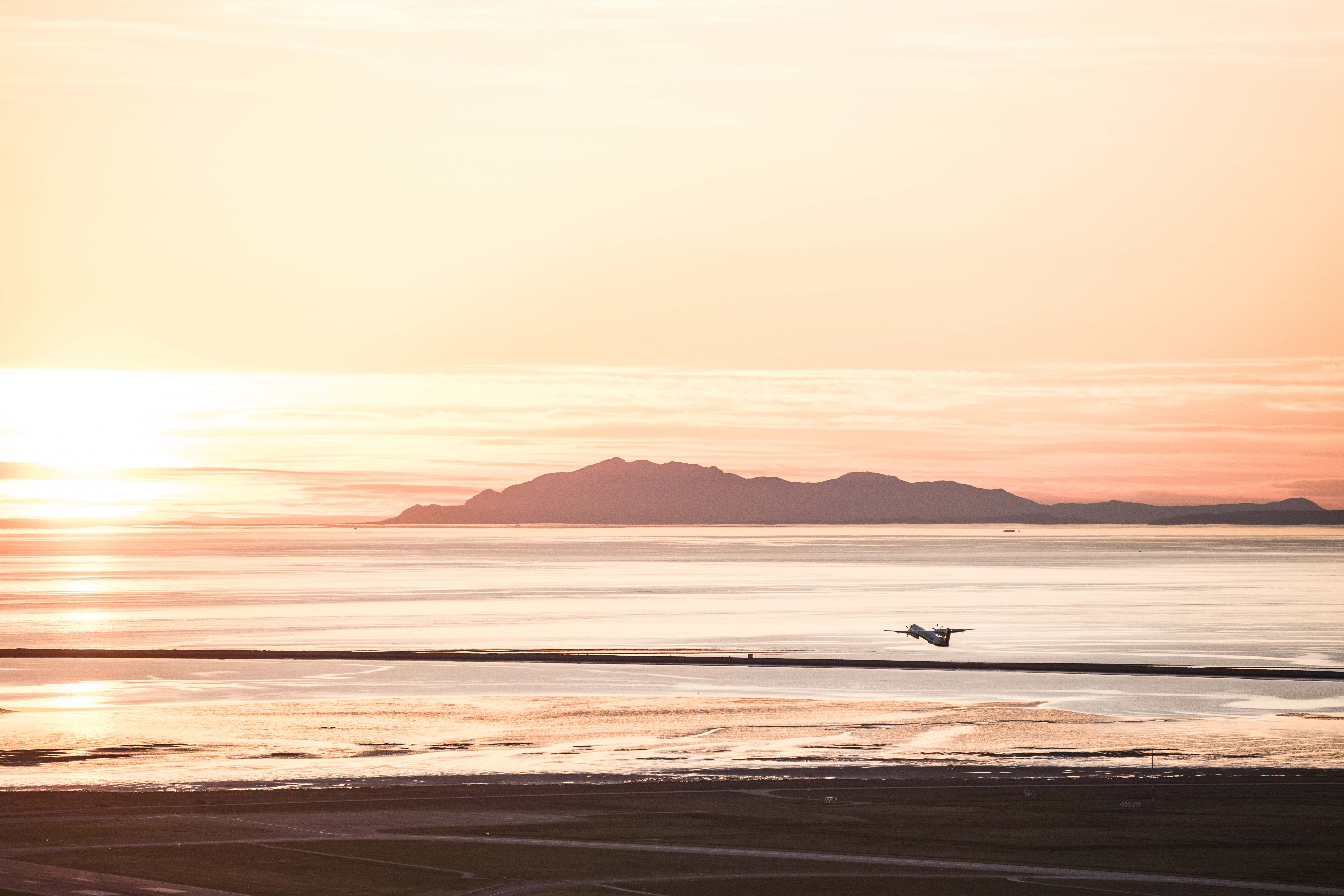 mountain backdrop with a plane taking off