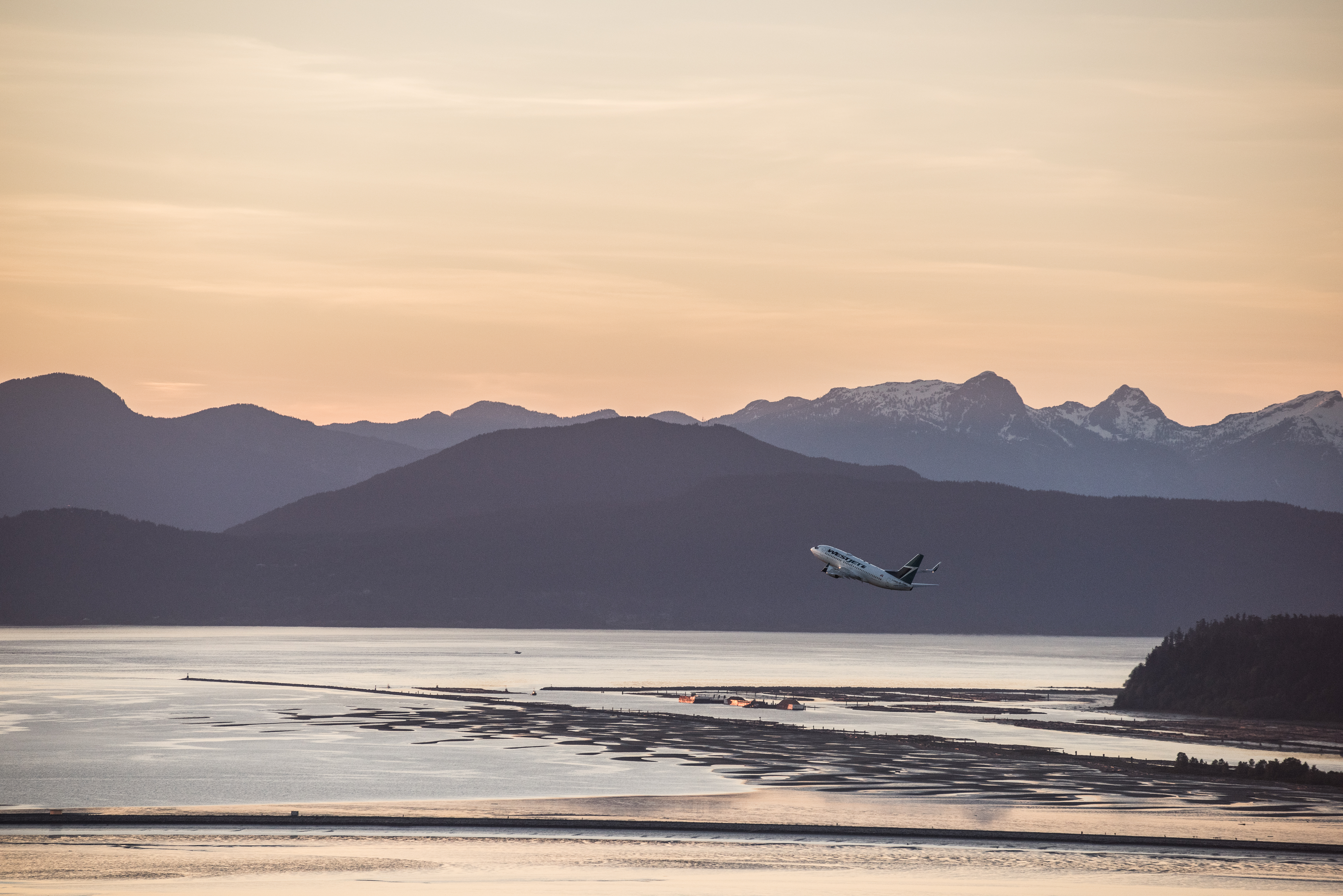 image of a plane taking off with the mountains in the background