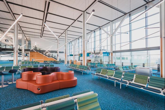 Pier D terminal gate seating with view of cathedral ceiling lighting and windows 